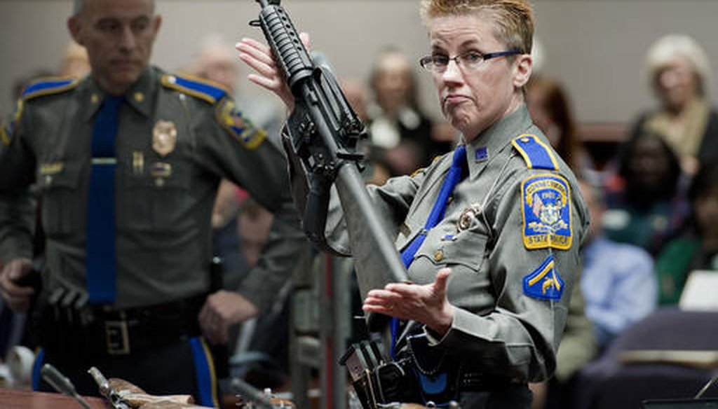 Firearms training unit Detective Barbara J. Mattson, of the Connecticut State Police, holds up a Bushmaster AR-15 rifle Jan. 28, 2013. (AP Photo/Jessica Hill, File)