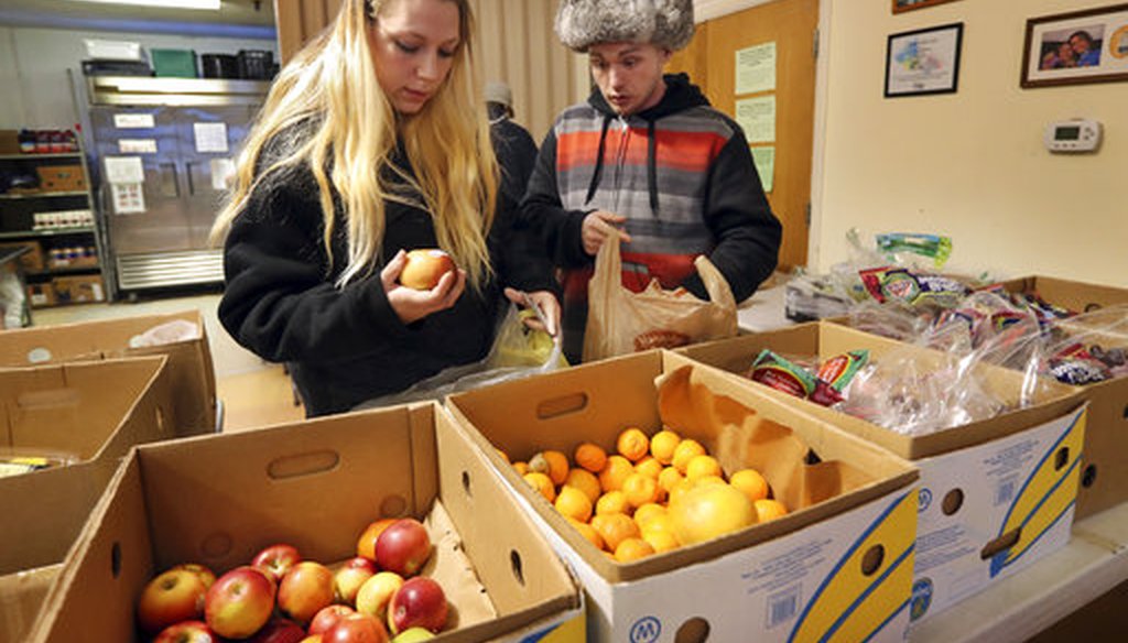 Sunny Larson, left, and Zak McCutcheon pick produce while gathering provisions to take home at the Augusta Food Bank in Augusta, Maine, on March 27, 2017. (AP/Robert F. Bukaty)