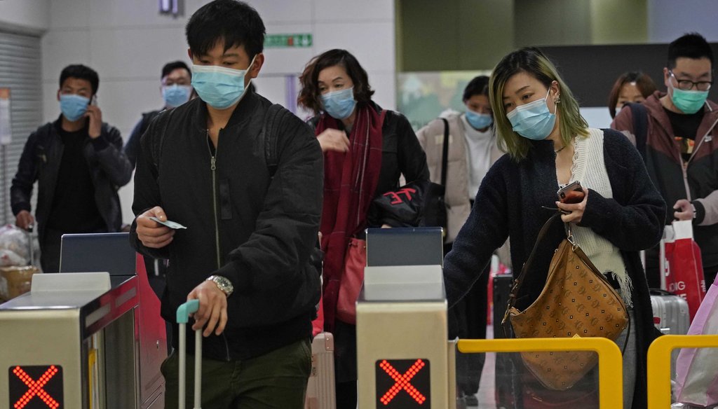 Passengers wear protective face masks arrive at the high speed train station in Hong Kong on Jan. 28, 2020. (AP)