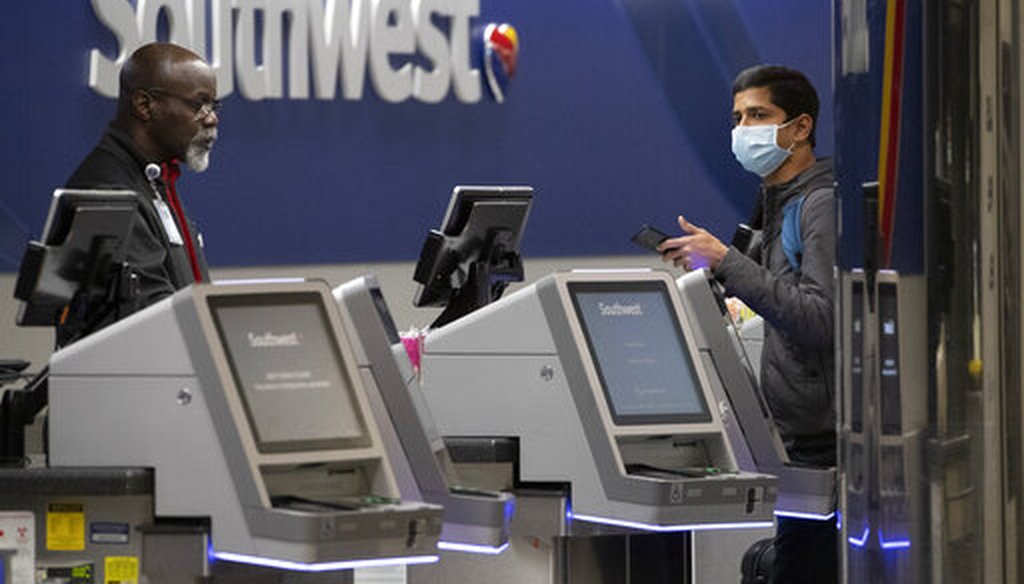 A Southwest Airlines employee helps a passenger wearing a facial mask at LaGuardia Airport on March 21, 2020, in New York, N.Y. (AP)