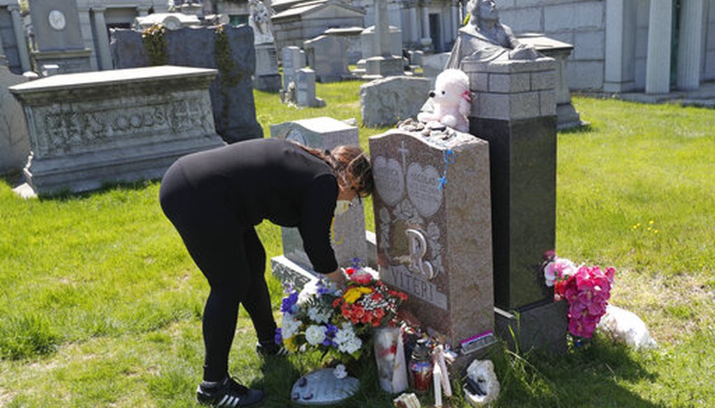 Sharon Rivera adjusts flowers left on her daughter's grave at Calvary Cemetery on Mother's Day, May 10, 2020, in New York. Rivera's daughter Victoria died at 21 of a drug overdose on Sept. 22, 2019. (AP)