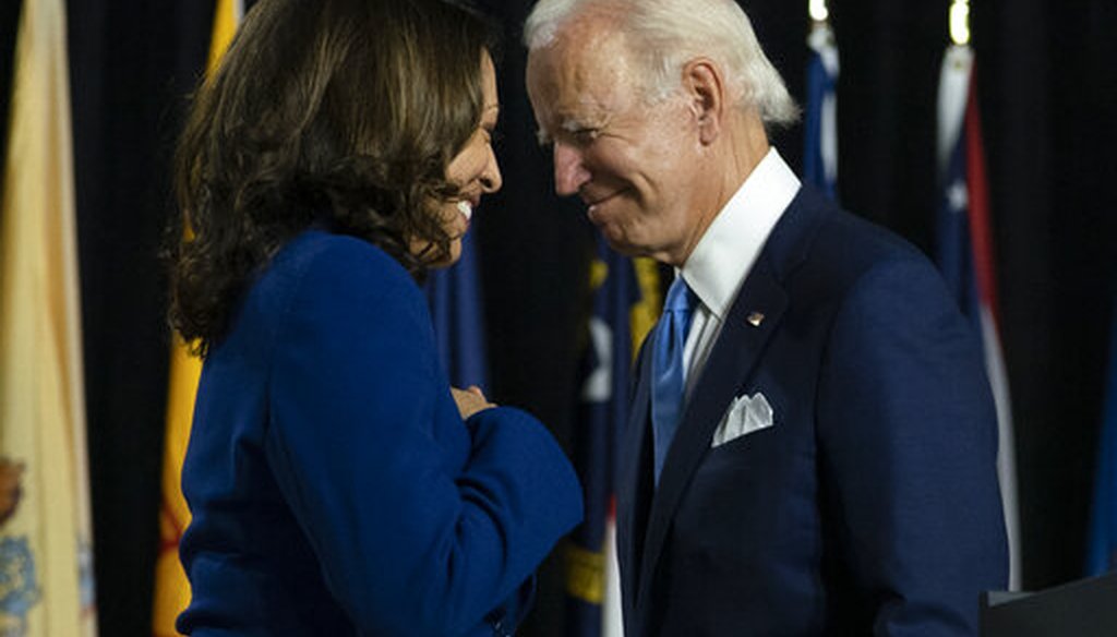 Democratic presidential candidate Joe Biden and his running mate, Sen. Kamala Harris, D-Calif., pass each other as Harris moves to the podium to speak during a campaign event in Delaware, Aug. 12, 2020 (AP)