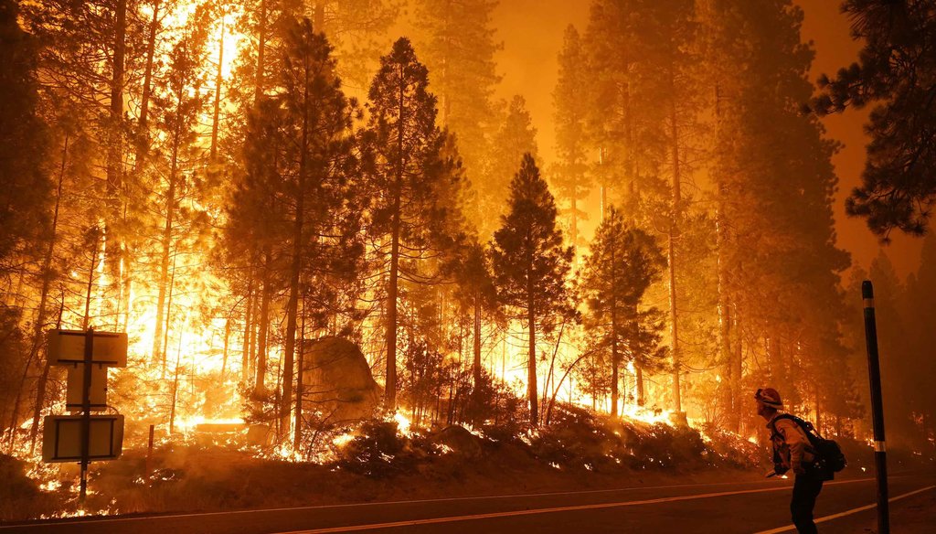 Gabe Huck, right, a member of a San Benito Monterey Cal Fire crew, stands along state Highway 168 while fighting the Creek Fire on Sept. 6, 2020, in Shaver Lake, Calif. (AP)