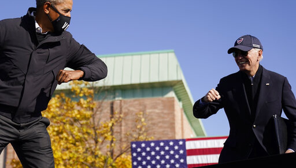 Democratic presidential candidate Joe Biden, right, and former President Barack Obama greet each other with an air elbow bump, at a rally in Flint, Mich., Oct. 31, 2020. (AP)