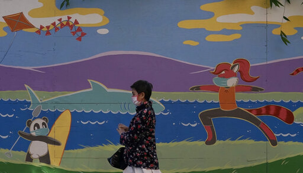 A pedestrian wears a mask while walking in front of a mural during the coronavirus pandemic in San Jose, Calif., Dec. 1, 2020. (AP)