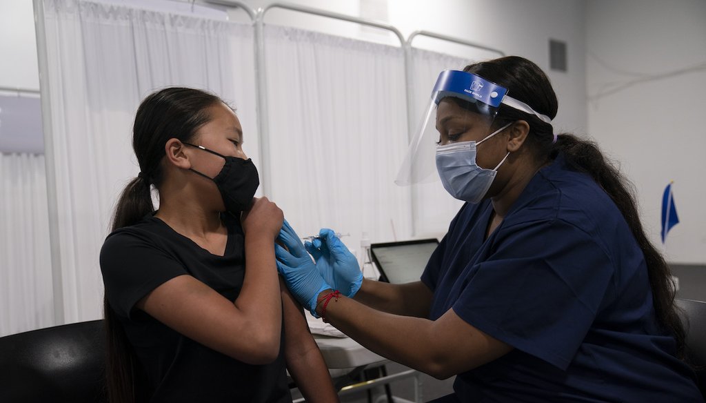 Payton Nguyen, 12, receives the Pfizer COVID-19 vaccine from nurse Lakera Thorne at Providence Edwards Lifesciences vaccination site in Santa Ana, Calif., on May 13, 2021. (AP)