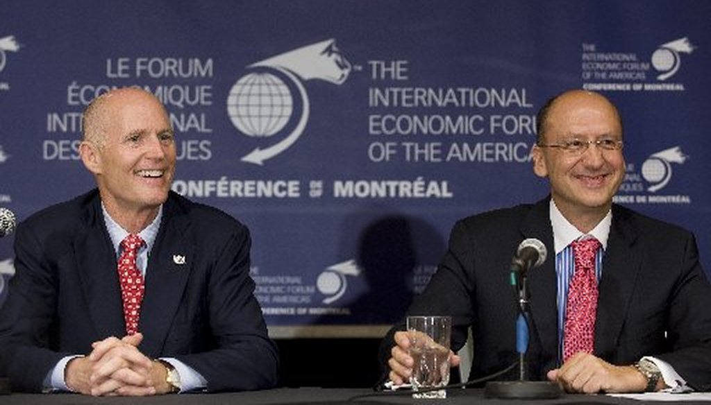Florida Gov. Rick Scott, left, and president and CEO of Garda World Stephan Cretier, laugh during a news conference at the International Economic Forum of the Americas in Montreal, June 8, 2011.