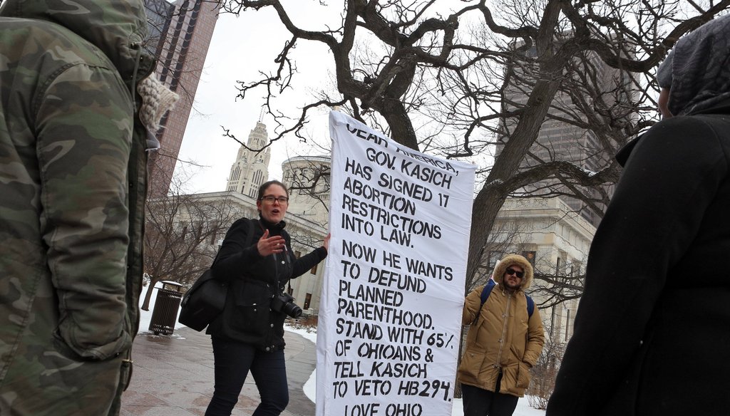 Anne Morrice of Planned Parenthood, Chris Maxie of Planned Parenthood, talk to Zahra Farah and Asha Abdulle of Columbus about the bill presented to Gov. John Kasich to defund Planned Parenthood at the Ohio Statehouse Feb. 10. (Columbus Dispatch via AP)