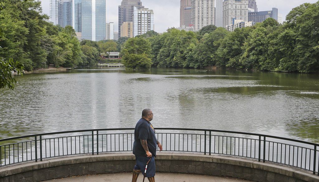 A walker in Piedmont Park enjoys the view of the Atlanta skyline in August. AJC photo by John Spink/JSpink@ajc.com