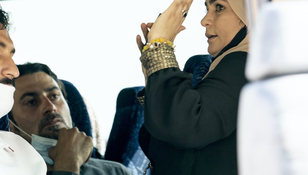 A woman steps onto an arriving bus carrying Afghanistan refugees to give them instructions as they arrive at a processing center in Chantilly, Va., Monday, Aug. 23, 2021, after arriving on a flight at Dulles International Airport. (AP)