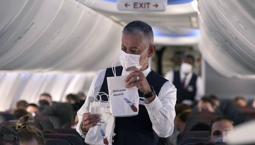 An American Airlines flight attendant hands out snack bags aboard a Boeing 737 Max jet before taking off from Dallas Fort Worth airport in Grapevine, Texas, Wednesday, Dec. 2, 2020. (AP)