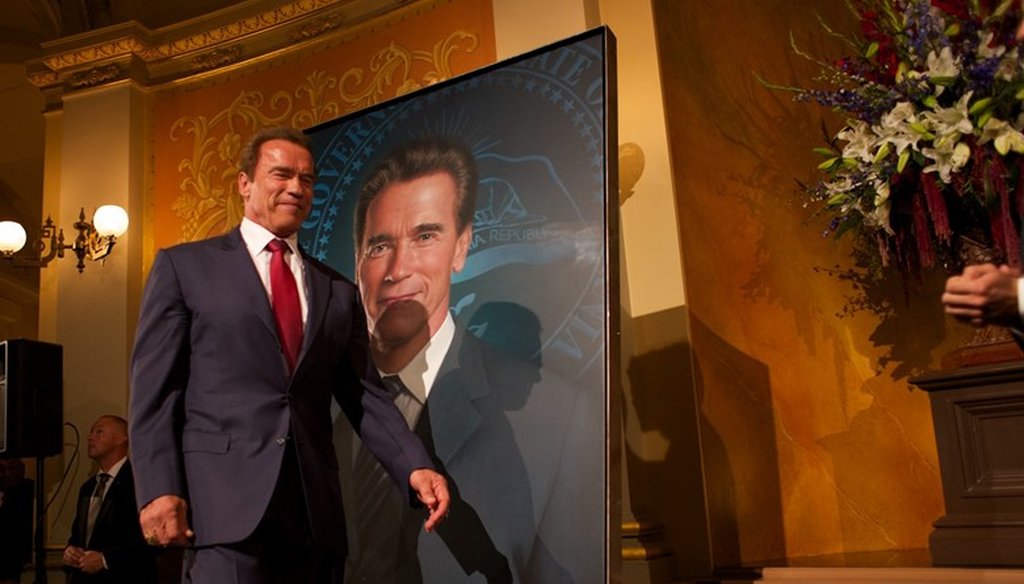 Former California Gov. Arnold Schwarzenegger walks past his portrait unveiled at the state Capitol in 2014. Andrew Nixon / Capital Public Radio