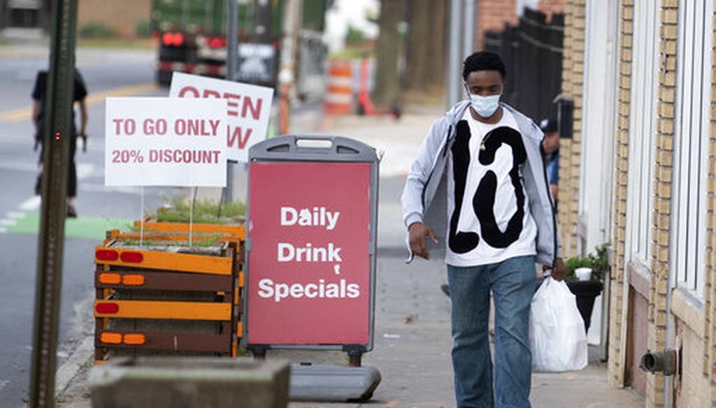 A man leaves a restaurant with a take-out order Thursday, March 19, 2020 in Atlanta. (AP)