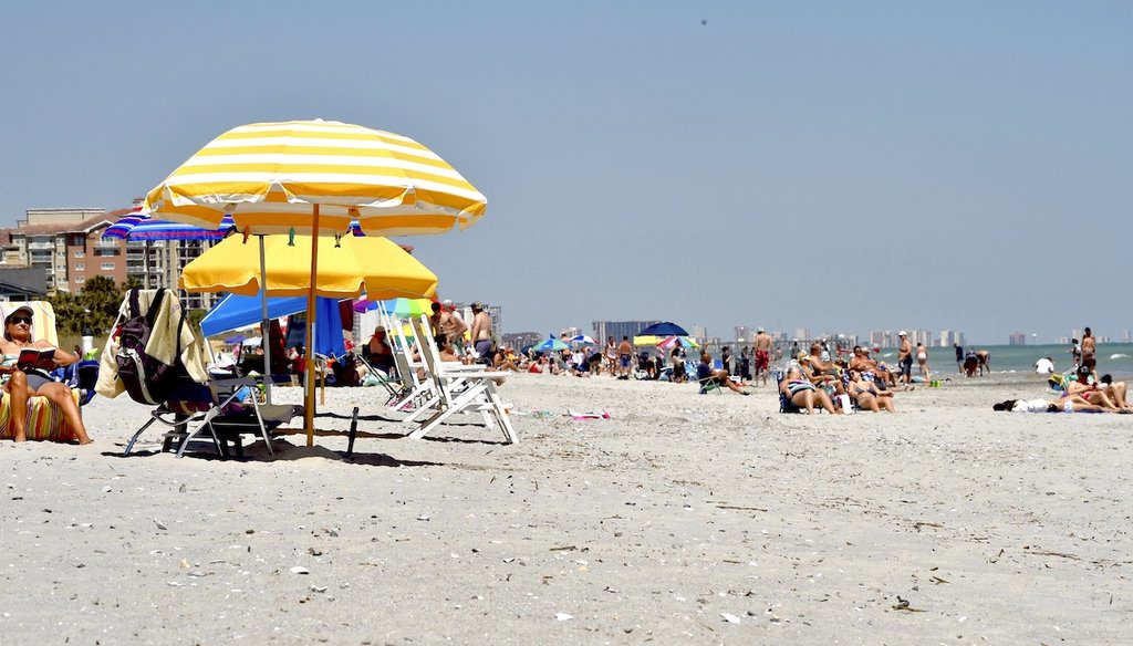 Visitors sit on the sand on Myrtle Beach, S.C., on May 2, 2020, amid the continuing coronavirus outbreak. (AP/Kinnard)