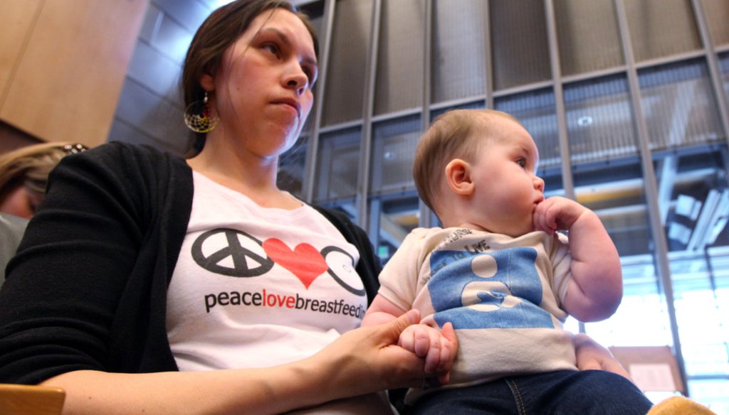 A woman holds her daughter after testifying in front of the Seattle City Council, April 9, 2012 (AP).