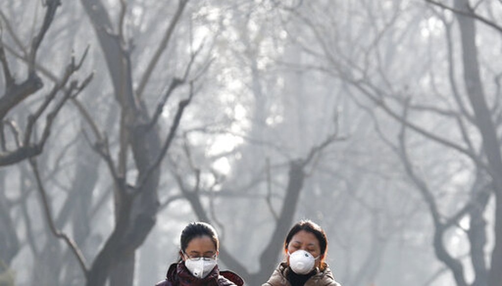 In this Dec. 19, 2016, file photo, women wearing masks to protect themselves from air pollution walk through Ritan Park shrouded by dense smog in Beijing. (AP)