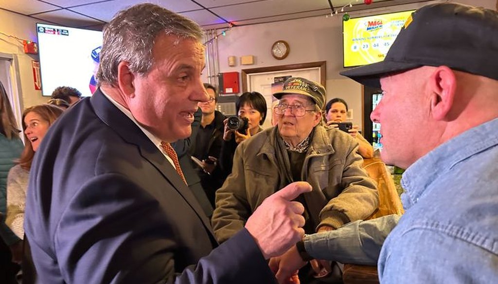Republican presidential candidate and former New Jersey Gov. Chris Christie speaks to a voter after an town hall in Londonderry, New Hampshire, on Dec. 13, 2023 (Rebecca Catalanello/PolitiFact)