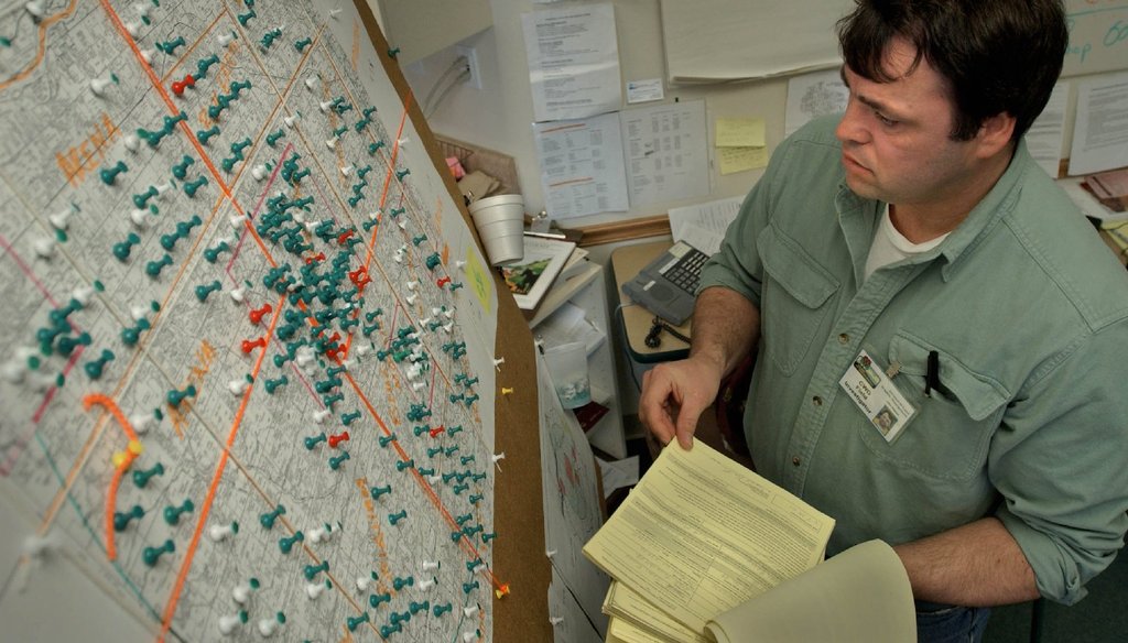 John Nielsen, a DNR wildlife biologist, consults a map containing an area to record where deer collecting permits have been issued in 2002. (Milwaukee Journal Sentinel) 