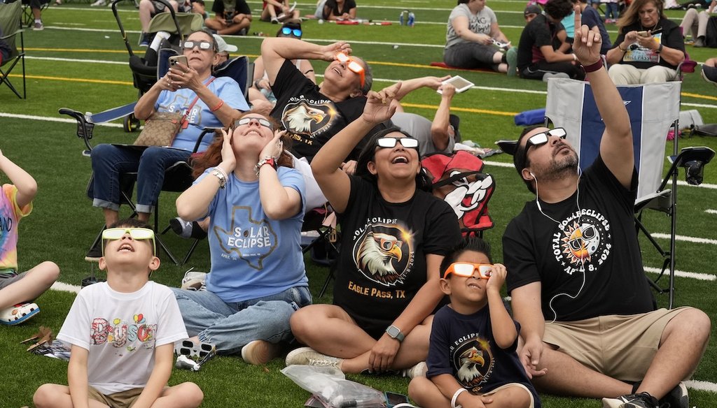 People watch as the moon partially covers the sun during a total solar eclipse, as seen from Eagle Pass, Texas, Monday, April 8, 2024. (AP)