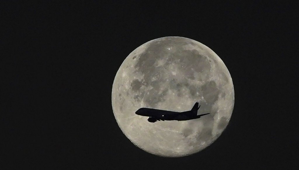An airplane passes in front of a full moon as it descends for landing in Mexico City, early Monday, Feb. 6, 2023. (AP)