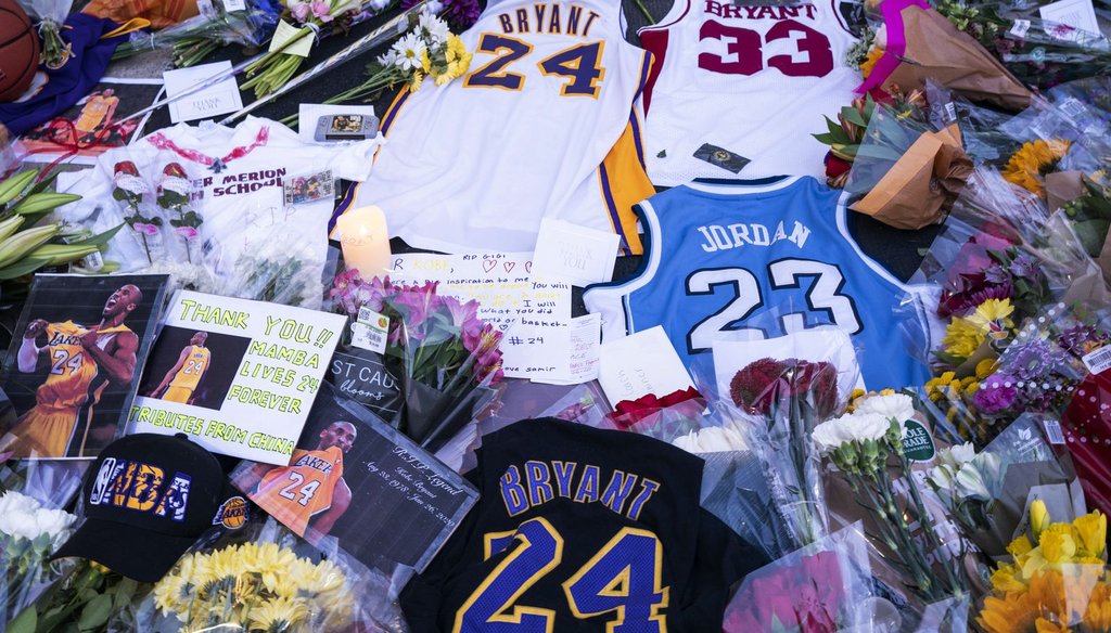 Flowers, jerseys and imagery are left in remembrance to Kobe Bryant at a small memorial at the entrance of the Bryant Gymnasium at Lower Merion High School, Monday, in Wynnewood, Pa. (AP)