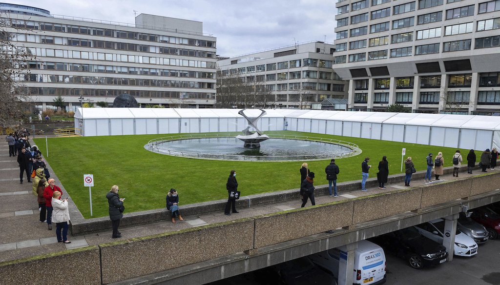 People queue up for COVID-19 booster shots outside a vaccination centre at St. Thomas Hospital in London on December 15, 2021. (AP)