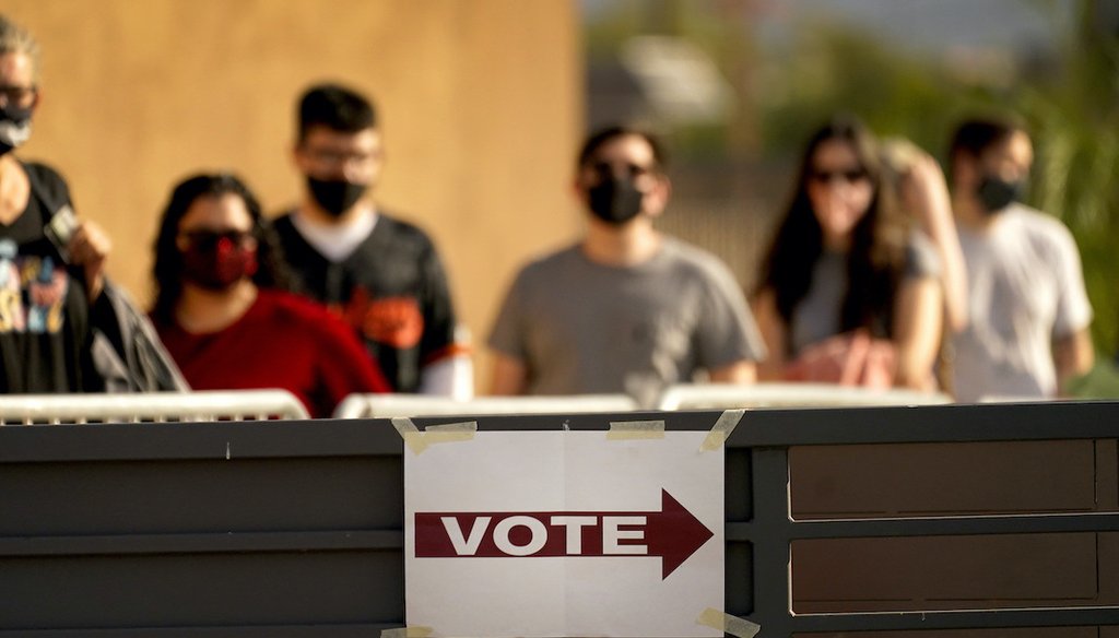 In this Tuesday, Nov. 3, 2020 file photo, Voters stand in line outside a polling station, on Election Day in Mesa, Ariz.