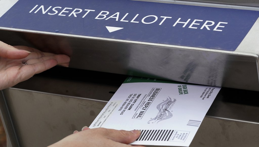 A Michigan voter inserts her absentee voter ballot into a drop box in Troy, Mich on Oct. 15, 2020. (AP)