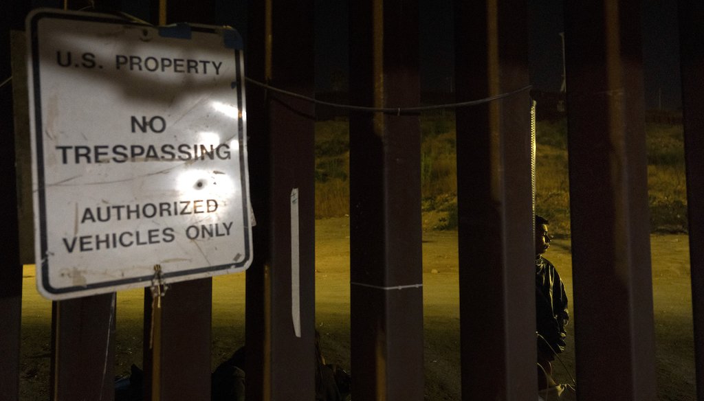 A migrant seeking asylum from Guatemala waits to be processed between two border walls, Tuesday, June 4, 2024, in San Diego. (AP)