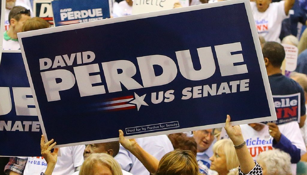 Supporters of David Perdue and Michelle Nunn wave signs just before the U.S. Senate debate at the Georgia National Fair on Oct. 7. Photo by Curtis Comptom/AJC.