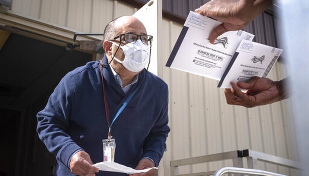 In this Thursday, Oct. 1, 2020 file photo, An employee of the Philadelphia Commissioners Office examines ballots at a satellite election office at Overbrook High School in Philadelphia. (AP)