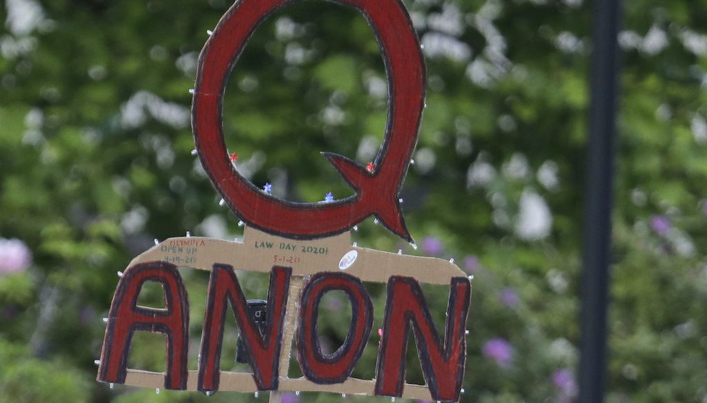 A person holds up a cardboard sign during a protest rally in Olympia, Wash., on May 14, 2020. (AP)