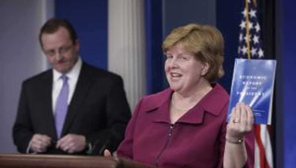 Council of Economic Advisers Chair Christina Romer holds up a copy of the 'Economic Report of the President' for 2010.