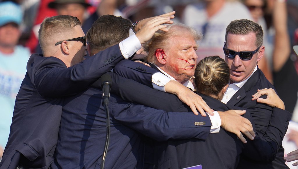 Republican presidential candidate former President Donald Trump is surrounded by U.S. Secret Service agents as he is helped off the stage at a campaign rally in Butler, Pa., on July 13, 2024. (AP)