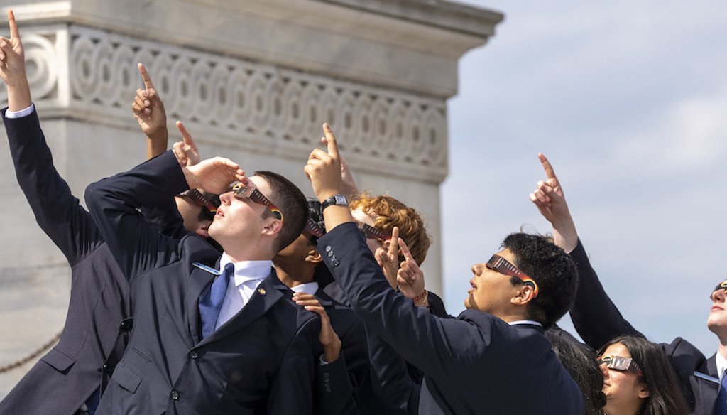 Senate pages wearing eclipse glasses view the solar eclipse in front of the U.S. Senate on Capitol Hill on April 8, 2024, in Washington. (AP)