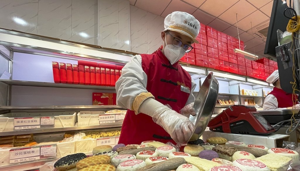 A worker packs a new year gift box with traditional pastries at a branch of Daoxiangcun, one of the best-known Chinese bakeries in Beijing, China, on Jan. 14, 2023. (AP)