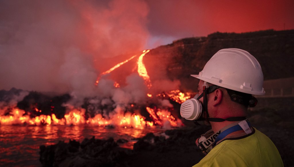 A scientist watches lava flows from a volcano reach the sea on the Canary island of La Palma, Spain, Nov. 11, 2021. (AP)