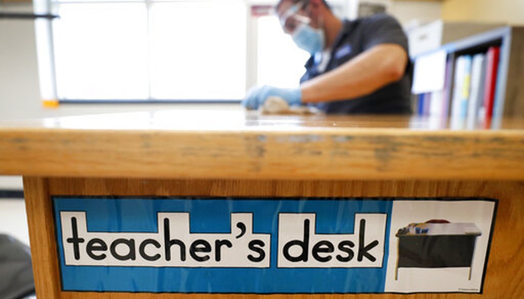 Des Moines Public Schools custodian Joel Cruz cleans a teacher's desk in a classroom at Brubaker Elementary School, Wednesday, July 8, 2020, in Des Moines, Iowa. (AP)