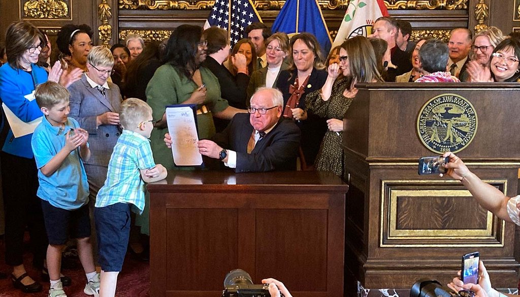 Democratic Minnesota Gov. Tim Walz jokes with kids May 25, 2023, as he shows off a bill he signed at the State Capitol in St. Paul, Minn., to establish a paid family and medical leave program in the state starting in 2026. (AP)