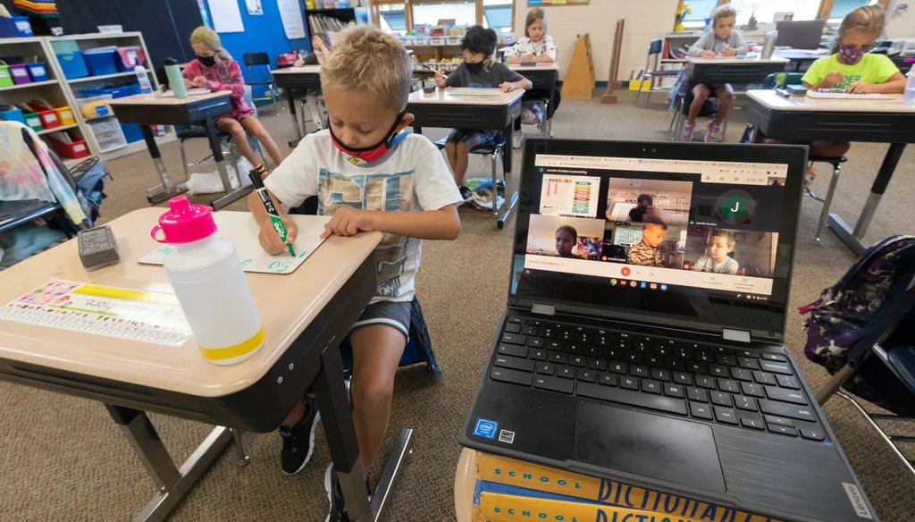 Second grade student Mason Fiore does classwork while next to a laptop with images of students working at home Sept. 4, 2020 at Lake Country School in Hartford. (Mark Hoffman/Milwaukee Journal Sentinel).